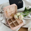 Travel jewelry case open with necklace and ring storage sections